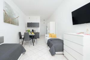 ein Schlafzimmer mit zwei Betten, einem Tisch und einem Fernseher in der Unterkunft Comfortable Studio for 3 People with Parking in Kołobrzeg by Noclegi Renters in Radzikowo + 8 Fotos