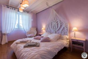a bedroom with a white bed with a white canopy at La demeure de zoé in Castelbiague