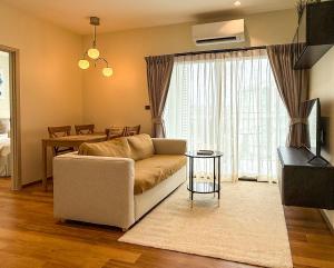 a living room with a couch and a table at Modern 1 & 2 Bedroom Apartments Naiyang Phuket by Mango Family in Nai Yang Beach