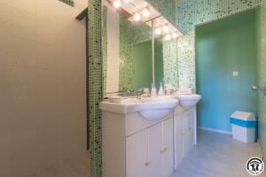 a bathroom with two sinks and a mirror at La demeure de zoé in Castelbiague +40 photos