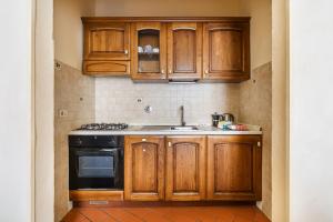 a kitchen with wooden cabinets and a stove at Inferno Double in Florence