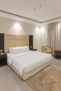 a bedroom with a large white bed and a chair at Taramuntan in Hail +71 photos