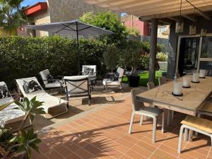a patio with a table and chairs and an umbrella at Villa Calma Tauro, Golf, Beach and Relax in La Playa de Tauro +30 photos