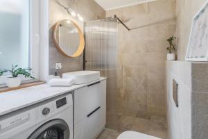 a bathroom with a washing machine and a mirror at Symphony of Light at Waterview in Oradea