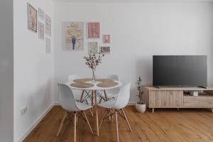 a dining room with a table and chairs and a tv at Symphony of Light at Waterview in Oradea +16 photos