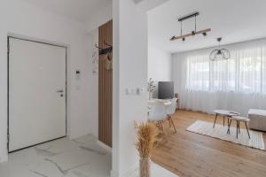 a white living room with a sliding glass door at Symphony of Light at Waterview in Oradea
