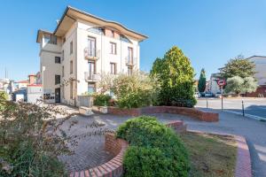 a white building with a brick walkway in front of it at La Casa di Leo in Stabbia