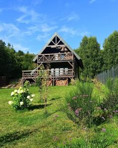 a large wooden barn in a field of grass at Domek w górach Łubinowa 6 in Międzylesie +20 photos