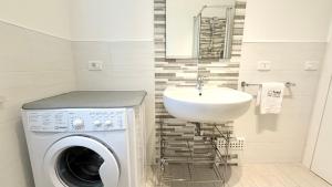 a bathroom with a washing machine and a sink at M272 - Marcelli, trilocale con giardino e posto auto in Marcelli