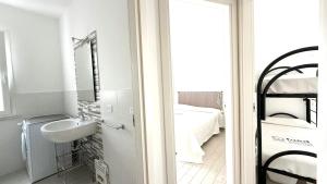 a white bathroom with a sink and a bed at M272 - Marcelli, trilocale con giardino e posto auto in Marcelli