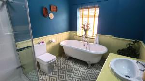 a bathroom with a tub and a toilet and a sink at Cosy and comfy 2 bedroom cottage with parking to the rear and a short drive from Cannock town centre in Hednesford +34 photos