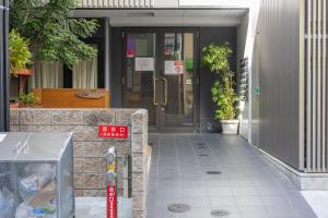 a door to a building with a sign in front of it at Shin-Imamiya Grand F in Osaka