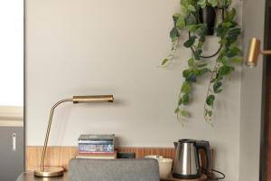 a desk with a lamp and a plant on the wall at Home Hotel Tapto in Stockholm
