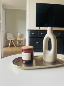 ein Raum mit einem Tisch mit einer Kerze und einer Vase in der Unterkunft La Mésange, vue montagnes à deux pas du lac in Thonon-les-Bains