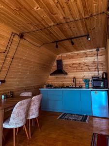 Gorists'ikheKvirike Cottage的厨房设有木墙和桌椅