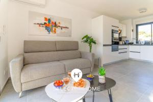 un salon avec un canapé et une table dans l'établissement SELECT' - T2 avec vue - Piscine et parking privé - CAPNAT-B08, à Bormes-les-Mimosas