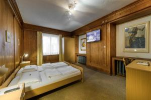 a bedroom with a large bed in a room at Poschiavo Suisse Hotel in Poschiavo