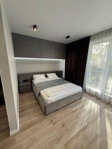 ein Schlafzimmer mit einem Bett und einem großen Fenster in der Unterkunft Premium Apartments A&S in Czernowitz