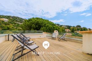 un groupe de chaises assises au-dessus d'une terrasse dans l'établissement SELECT'soHOME - Villa avec piscine, spa et babyfoot pour 10 personnes à proximité de la plage d'Aiguebelle ! - 5 ETOILES - VILLA MANDARINIERS, au Lavandou