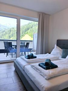 two beds in a room with a view of a balcony at WeitBlick Appartements in Wagrain