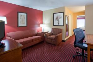Habitación de hotel con sofá y silla en GrandStay Hotel & Suites - Stillwater, en Stillwater