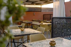 ein leeres Restaurant mit Tischen und Stühlen in einer Cafeteria in der Unterkunft Riad Nejma Benyoussef in Marrakesch