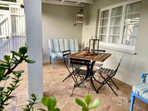 赫曼努斯Hermanus Self-Catering的门廊上摆放着桌椅的露台