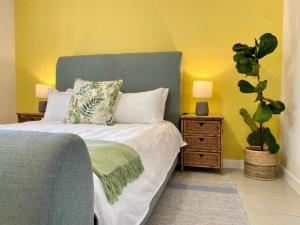 赫曼努斯Hermanus Self-Catering的一间带床和盆栽的卧室