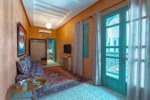ein Wohnzimmer mit einer Tür, die auf einen Balkon führt in der Unterkunft Riad Nejma Benyoussef in Marrakesch