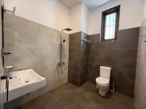 a bathroom with a toilet and a sink at Eagles' Hideout in Bowala