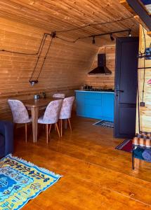 a dining room with a table and chairs and a kitchen at Kvirike Cottage Kazbegi in Gorists'ikhe +10 photos