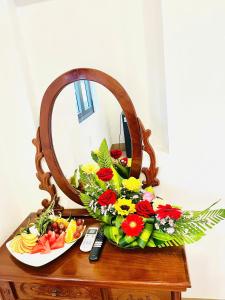 a table with a plate of flowers and a mirror at Homestay Lumia Gold in Quy Nhon
