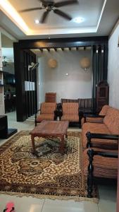 a living room with couches and a table on a rug at D Aida Homestay in Kampong Bukit Katil