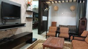 a living room with a couch and a tv at D Aida Homestay Bukit Katil in Kampong Bukit Katil