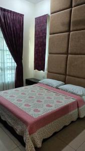a bedroom with a bed with a red and white blanket at D Aida Homestay in Kampong Bukit Katil
