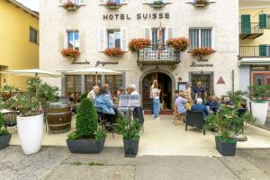 eine Gruppe von Menschen sitzt vor einem Hotel in der Unterkunft Hotel Suisse, Swiss Alpine Charm in Poschiavo + 26 Fotos