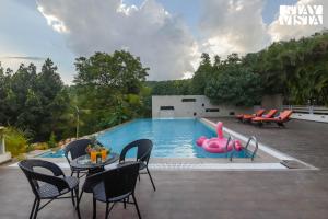 a swimming pool with a pink flamingo in the water at StayVista at Anandam Lake Villa - Khadakwasla in Pune