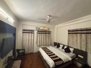 Un dormitorio con una cama y un televisor de pantalla plana. en HOTEL O THE 9 CUBE, en Habībganj