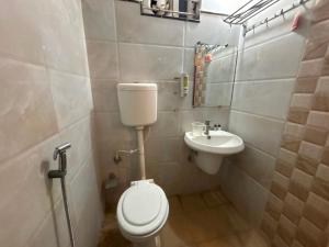 Un baño pequeño con inodoro y lavabo. en HOTEL O THE 9 CUBE, en Habībganj