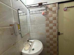 Un baño con un lavabo blanco y un espejo. en HOTEL O THE 9 CUBE, en Habībganj