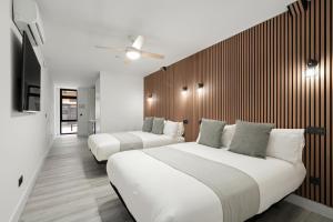 two beds in a room with white and wooden walls at Dobo Pinto Castillo in Pinto