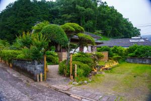 a house with trees and bushes in a yard at お宿竹あかりOyado Takeakari in Takachiho