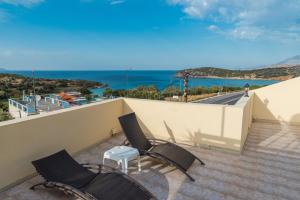 a balcony with two chairs and a view of the ocean at Vrokastro Apartments in Istro