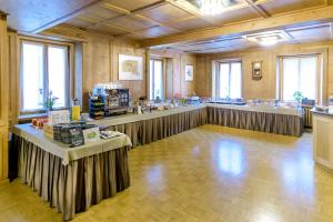 a large room with tables in the middle of it at Poschiavo Suisse Hotel in Poschiavo