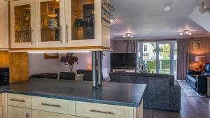 a kitchen with a counter top and a living room at Venture Lakeside Lodge in South Cerney