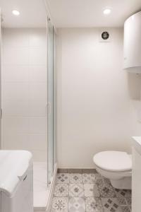 a white bathroom with a toilet and a shower at Ideally located studio Foch & Parc de la Tête d’Or in Gare des Brotteaux