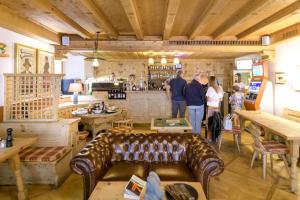 Eine Gruppe von Menschen steht in einem Raum mit einer Couch in der Unterkunft Hotel Suisse, Swiss Alpine Charm in Poschiavo