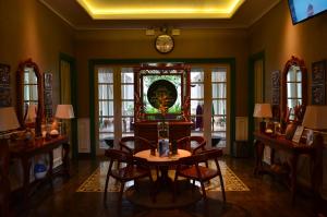 Habitación con mesa, sillas y reloj en Rumah Jawa Guest House (Syariah), en Yogyakarta