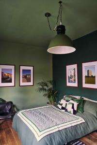 a bedroom with a bed and a green wall at Mid-Century charm in the heart of Stroud in Stroud