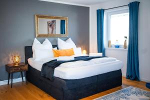 a bedroom with a large bed with orange and white pillows at 90m2 Loft I Kaffee I Terrasse I E-Parkplatz I 65' Smart TV in Rosenheim